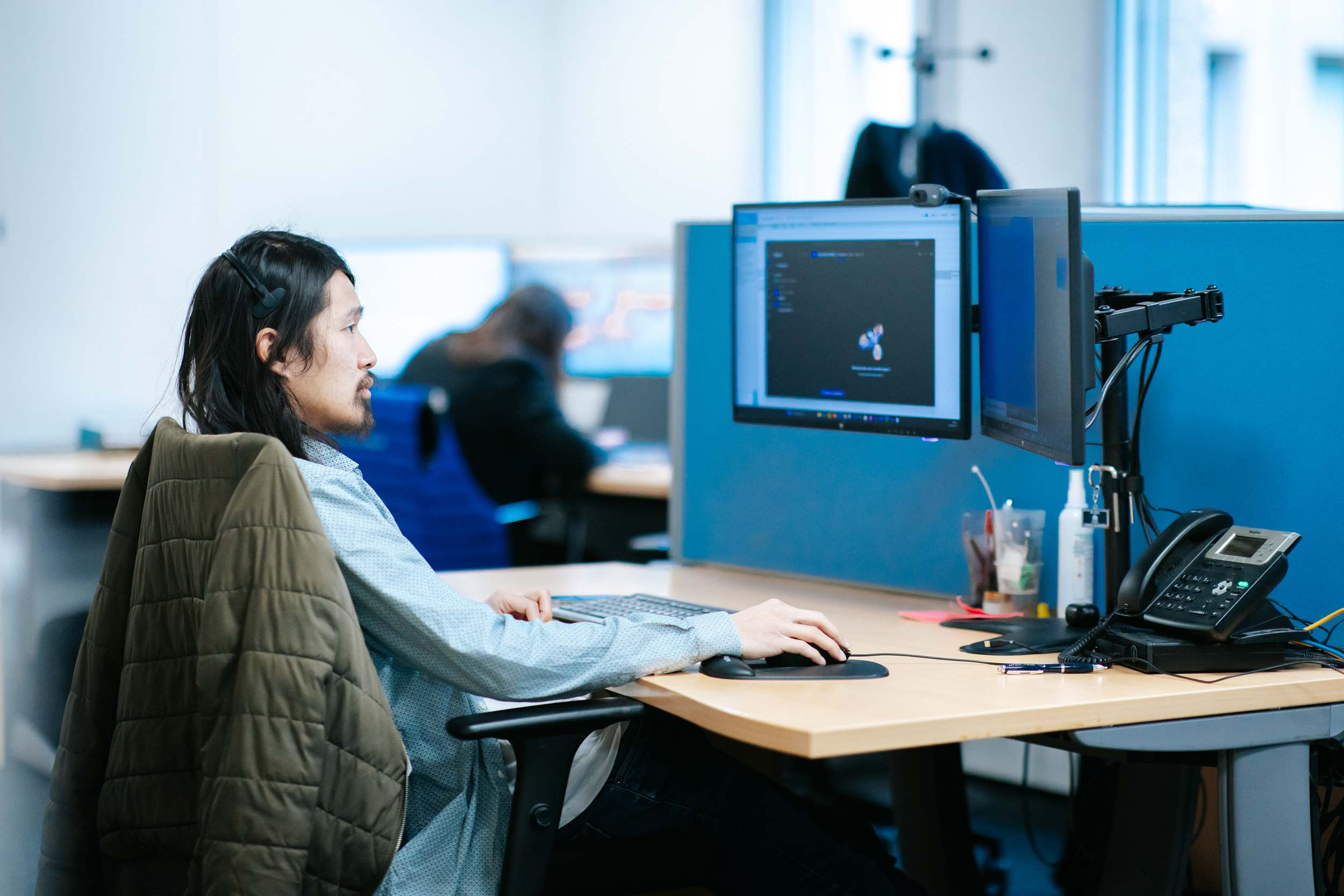 Photo d'un informaticien entrain de travailler sur des ordinateurs